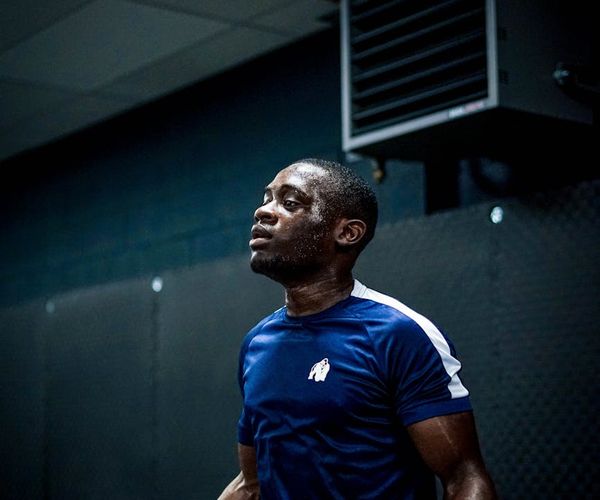 Man performing jump cardio exercise in a dark studio